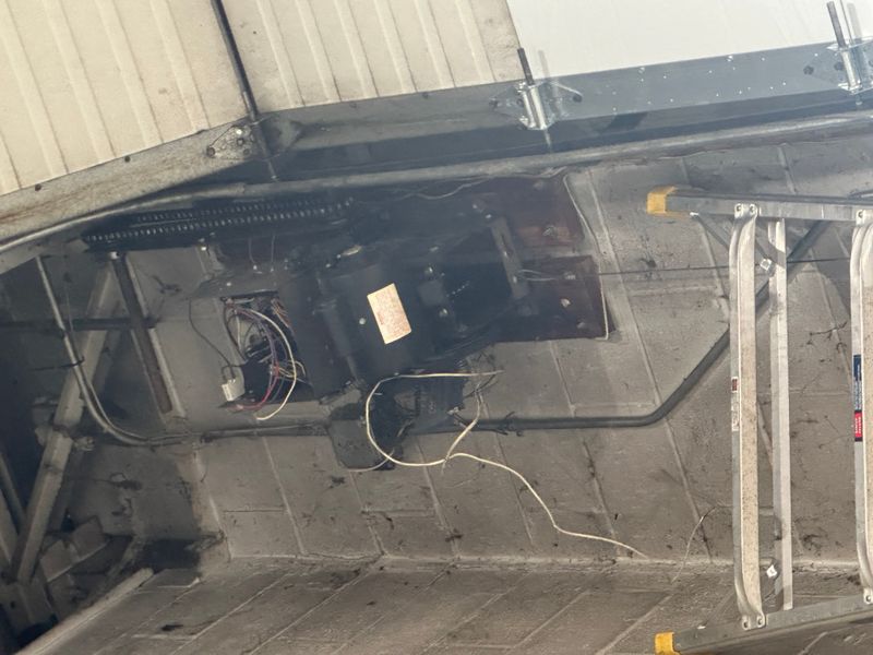 Close-up of commercial garage door opener motor and spring system during repair